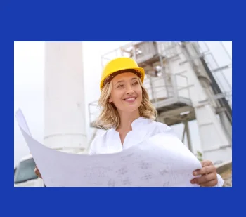 Een bouwspecialist die projectblauwdrukken bekijkt terwijl hij bij een industriële faciliteit staat.