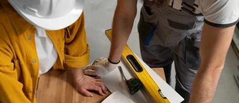 Bouwprofessionals die ter plaatse samenwerken terwijl ze indelingen en bouwdetails inspecteren.